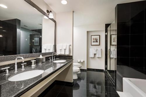 a bathroom with two sinks and a toilet and a mirror at Marriott Dallas/Fort Worth Westlake in Westlake