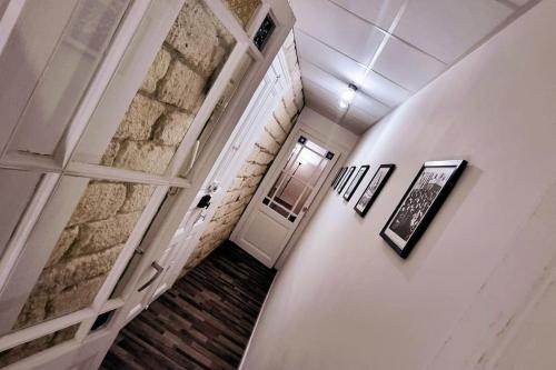 un couloir avec une porte blanche et un mur en briques dans l'établissement LE PARC Authentique Coeur de Ville Proximité Parking Climatisé, à Sète