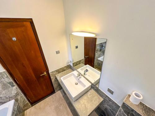 a bathroom with a sink and a mirror at Flaming Tree Resorts in Kiriwan Eliya