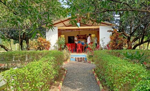 una casa con un gruppo di persone seduti sotto il portico di Renewed Jadeshwar Farm Resort a Sasan Gir