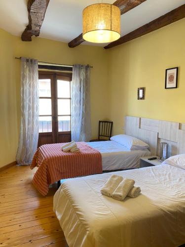 a bedroom with two beds and a window at Hotel Restaurante Agapio de TRESNIÑO in Quintanilla de Onésimo