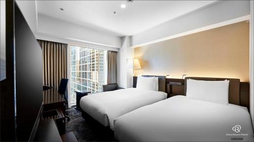 um quarto de hotel com duas camas e uma janela em Daiwa Roynet Hotel Nishi-Shinjuku PREMIER em Tóquio