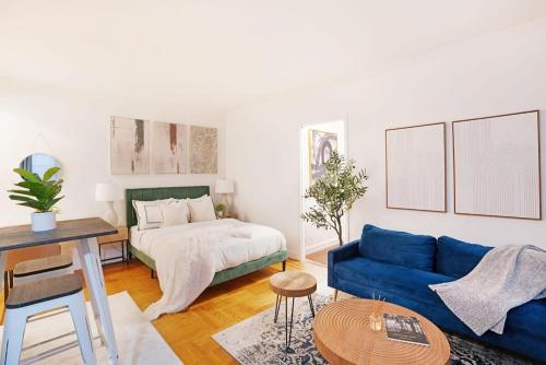 a living room with a blue couch and a bed at 105-1G Park Ave Location studio best value Sleeps3 in New York