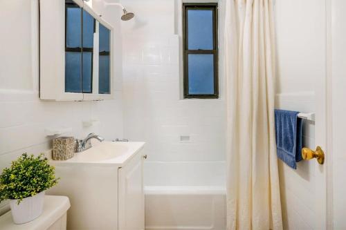 La salle de bains blanche est pourvue d'un lavabo et d'une douche. dans l'établissement 105-1G Park Ave Location studio best value Sleeps3, à New York