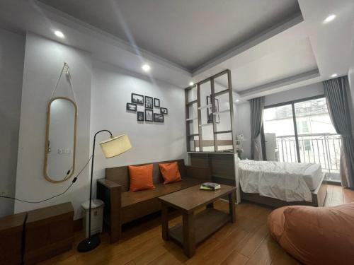 Schlafzimmer mit einem Bett, einem Spiegel und einem Tisch in der Unterkunft Ann's Studio in Hanoi