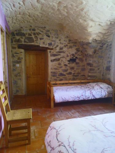 a bedroom with a bed and a stone wall at L'Asphodèle in Venterol