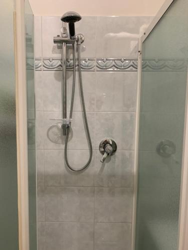 y baño con ducha y puerta de cristal. en Appartamento La Piazza en Montese