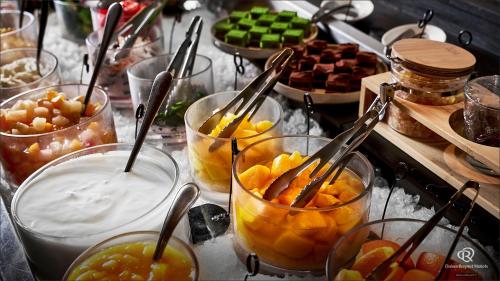 a buffet of food with bowls of fruit and utensils at Daiwa Roynet Hotel Nishi-Shinjuku PREMIER in Tokyo