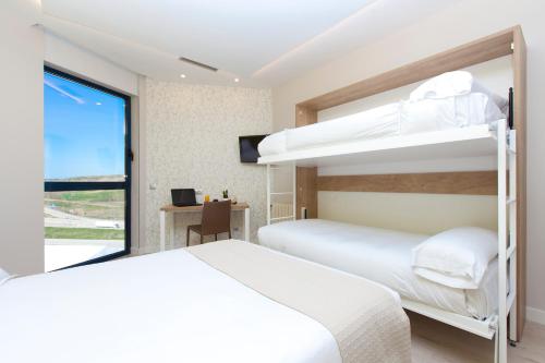 two bunk beds in a room with a window at Spirit Hotel Ciudad de Burgos in Rubena