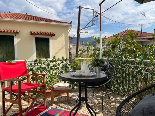 a patio with a table and chairs and a fence at Thalgiron, a breath away from Delphi in Ámfissa