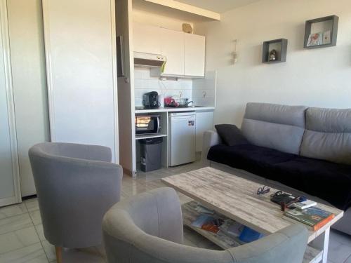 een woonkamer met een bank en een tafel bij Studio vue mer pour 2 personnes au Port de Valras-Plage in Valras-Plage