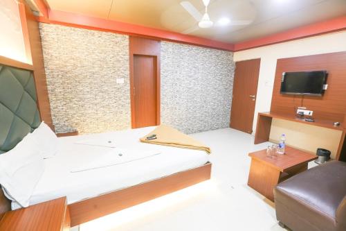 Habitación pequeña con cama y TV. en HOTEL GODAVARI INN en Mire