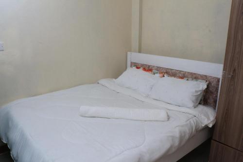 a white bed with two towels on top of it at Chaka Homes in Kiganjo