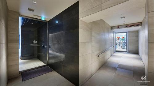 un couloir avec douche à l'italienne dans un bâtiment dans l'établissement Daiwa Roynet Hotel Nishi-Shinjuku PREMIER, à Tokyo