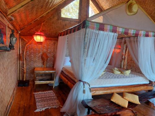 a bedroom with a canopy bed in a room at Jungle Bar Honeymoon suite & private pool in San Vicente