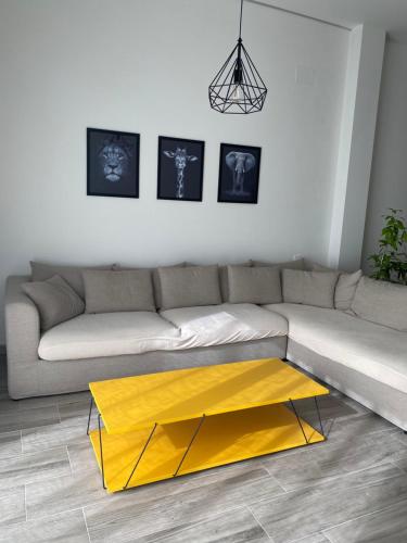 a living room with a couch with a yellow coffee table at Casa de Goya in Argés