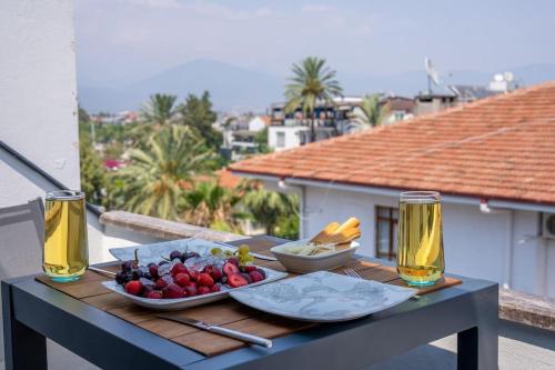 フェティエにあるFethiye Şehir Merkezinde Lüks Daire - OcekHomes Adinの食べ物の載ったトレイとビール2杯が置かれたテーブル