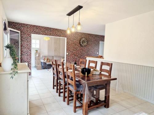a kitchen and dining room with a wooden table and chairs at Les Capucines in Portbail