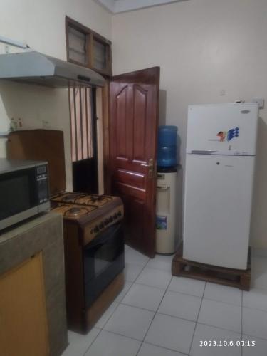 eine Küche mit einem Herd und einem Kühlschrank in der Unterkunft Sp Accommodations in Mombasa