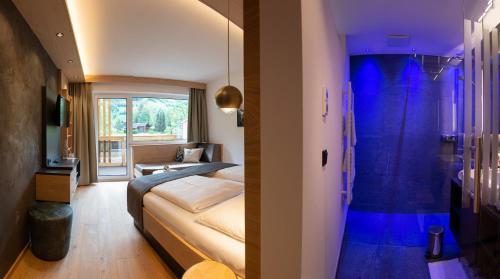 a bedroom with two beds and a blue room at Hotel Alpina in Rauris