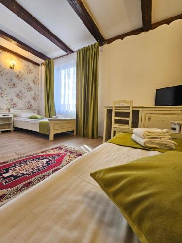 a bedroom with a large bed and a desk at Hanul Vestem in Sibiu