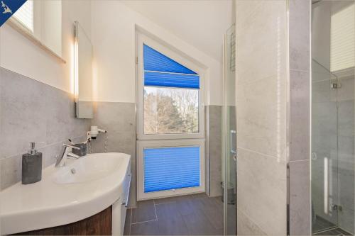 ツィノヴィッツにあるHaus Ostseekristall Wohnung Saphirのバスルーム(シンク、青いブラインド付きの窓付)