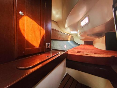 Habitación pequeña con cama y armario de madera. en Sailing Life Style - Rejsy mazurskie ze sternikiem., en Kolonia Rybacka
