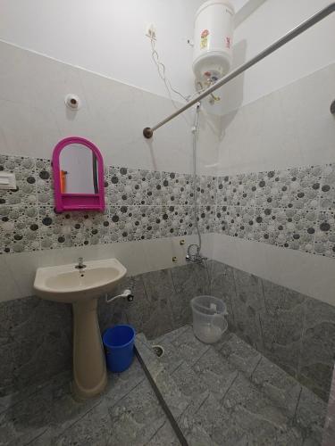 a bathroom with a sink and a pink mirror at Urban Nest Residence in Mysore