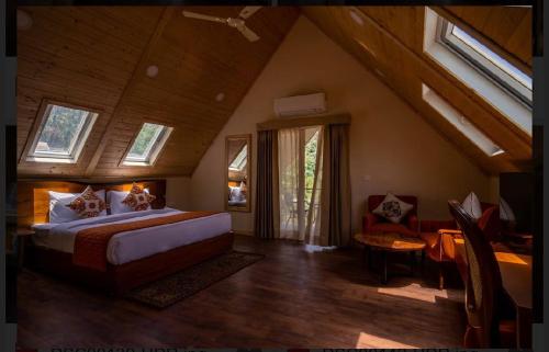 ein Schlafzimmer mit einem großen Bett im Dachgeschoss in der Unterkunft Samsara Luxury Cottages & Spa !! Best Resort in Chail in Chail