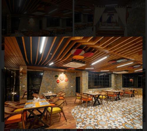 comedor con mesas y sillas de madera en Samsara Luxury Cottages & Spa !! Best Resort in Chail, en Chail