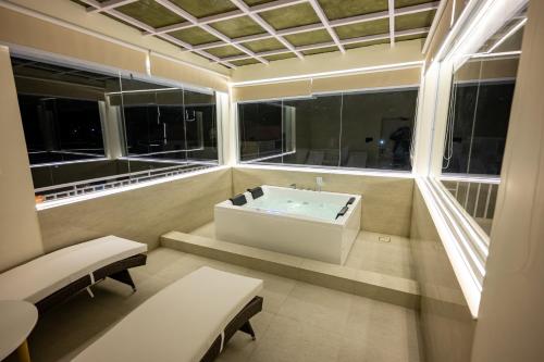 Habitación con ventanas y baño con bañera. en Luxury 3BHK Villa in Dharamshala with Jacuzzi, en Kangra
