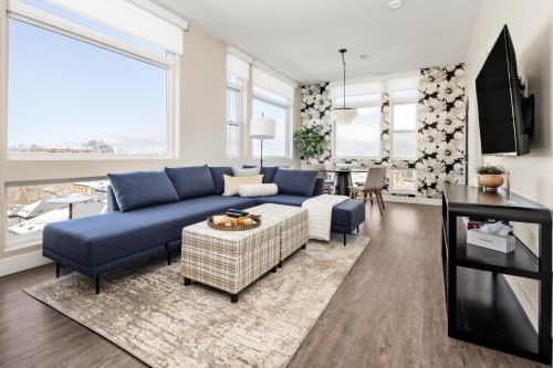 a living room with a blue couch and a table at Top Floor - Amazing Windows - Zuni Lofts in Denver