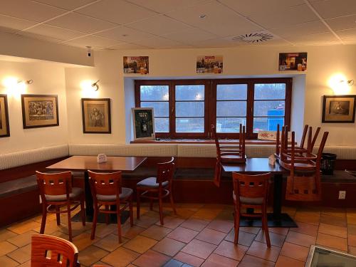 - un restaurant avec des tables et des chaises dans une salle dans l'établissement Pohostinství v Holi, à Průhonice