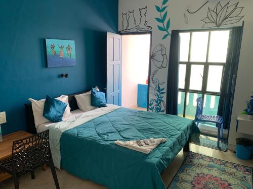 1 dormitorio con 1 cama grande y paredes azules en Seagreen Beach resort en Pallipuram