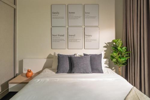 a bedroom with a white bed with a poster on the wall at DingD0ng Home FelizEnVista 5-star facilities in Ho Chi Minh City