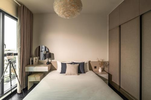 a bedroom with a large bed and a large window at DingD0ng Home FelizEnVista 5-star facilities in Ho Chi Minh City