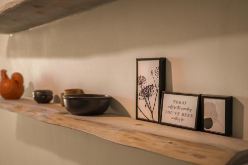 a shelf with two pictures and a bowl on it at DingD0ng Home FelizEnVista 5-star facilities in Ho Chi Minh City