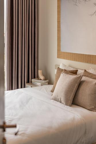 a bedroom with a large white bed with pillows at DingD0ng Home FelizEnVista 5-star facilities in Ho Chi Minh City