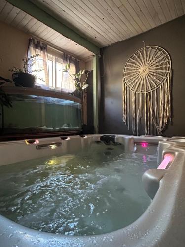 bañera de hidromasaje con ventilador en el baño en Chambre d’hôte avec Sauna & Jacuzzi, en Les Lèves-et-Thoumeyragues
