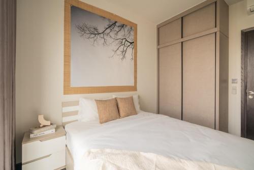 a bedroom with a white bed and a picture on the wall at DingD0ng Home FelizEnVista 5-star facilities in Ho Chi Minh City