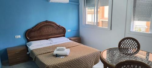 ein Schlafzimmer mit einem Bett, einem Tisch und einem Stuhl in der Unterkunft Hostal Europa in Tarragona