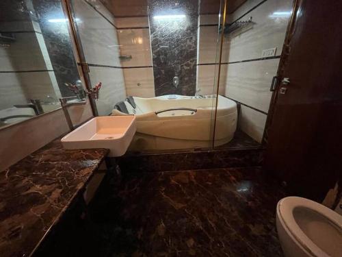 a bathroom with a sink and a toilet at Luxury 4BHK Penthouse with Theatre, Jacuzzi & Private Terrace in Navi Mumbai