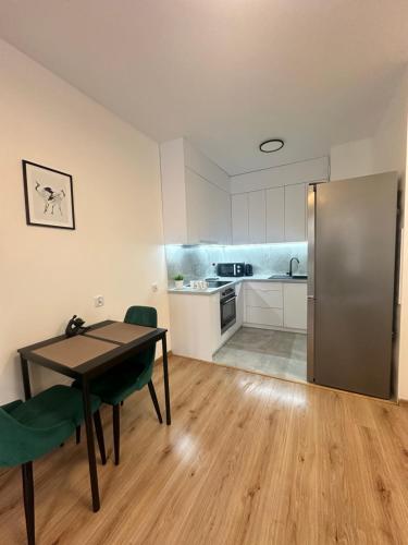 a kitchen with a table and chairs and a refrigerator at Apartament ŻELAZNY HGS Home in Gorzów Wielkopolski
