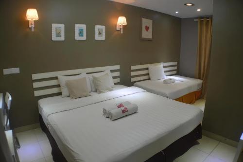 a hotel room with two beds with white sheets at Boutique Hote123 in Kuala Lumpur