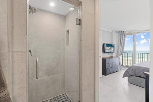 una ducha con puerta de cristal en un dormitorio en Oceania Plaza 405, en New Smyrna Beach