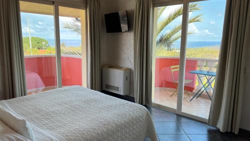 a bedroom with a bed and a view of the ocean at Borgo di Santa Barbara in Santa Domenica