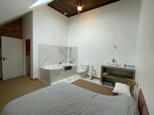 une chambre avec un lit et une salle de bain avec un lavabo dans l'établissement Pépé grange rénovée, à Annoire
