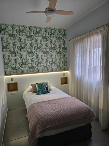 a bedroom with a bed with a floral wall at Mi Rincon en La Pedrera in Tejina