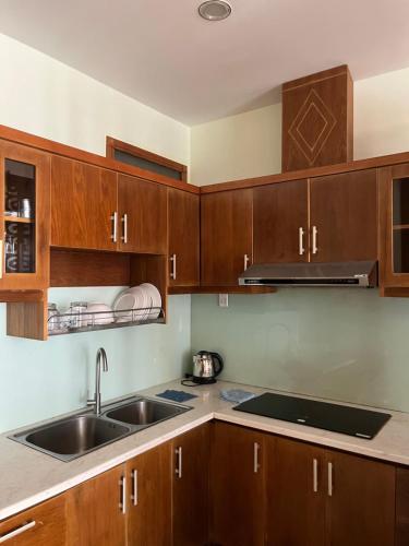 una cocina con armarios de madera y fregadero en Thuy Tien Seaview Apartment -1602, en Vung Tau