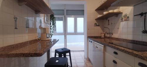 eine Küche mit einer Theke und einem Hocker darin in der Unterkunft ARENA y Mar Sunny Home by Cadiz4Rentals in Cádiz